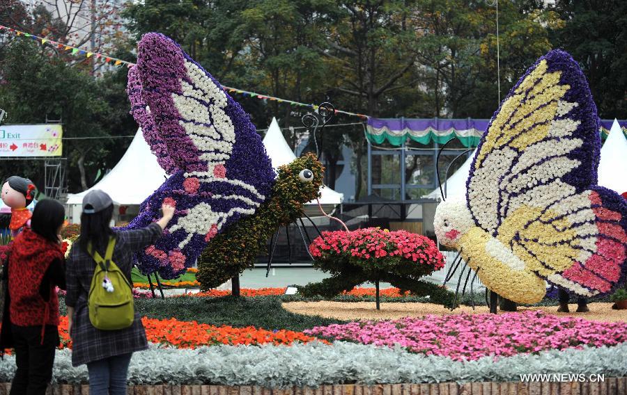 Two visitors take pictures by a parterre at a flower show in south China's Hong Kong, March 14, 2013. The 10-day Hong Kong Flower Show 2013, which will kick off on March 15, 2013 at Victoria Park, opened to media for a preview on Thursday. More than 200 organizations contributed some 350,000 flowers to the show. (Xinhua/Zhao Yusi) 