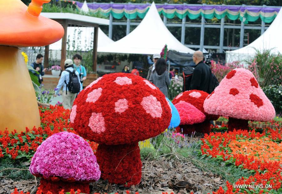 People visit a mushroom-shaped parterre displayed at a flower show in south China's Hong Kong, March 14, 2013. The 10-day Hong Kong Flower Show 2013, which will kick off on March 15, 2013 at Victoria Park, opened to media for a preview on Thursday. More than 200 organizations contributed some 350,000 flowers to the show. (Xinhua/Zhao Yusi) 
