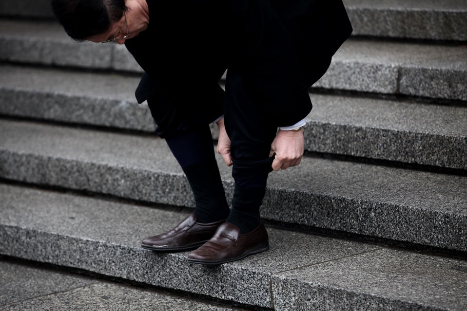 A CPPCC member gets prepared to walk into the water by rolling up his trousers on the steps. The closing meeting of the first session of the 12th National Committee of the Chinese People's Political Consultative Conference (CPPCC) was held on Tuesday. On the same day, Beijing embraced the first spring rain in 2013. (Xinhua News Agency/Liu Jinhai)