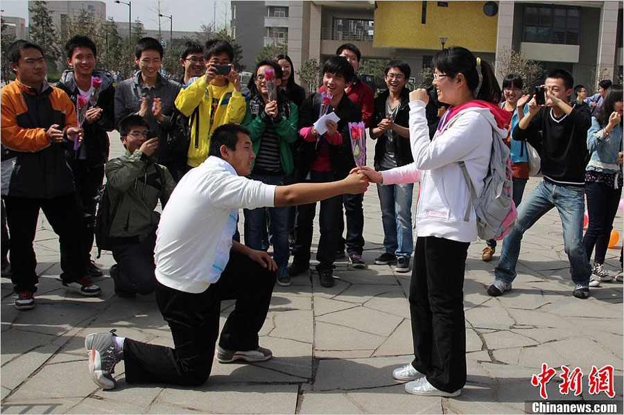 A young student at the Northwestern Polytechnical University courts a girl by sending her a flower on "Ladies' Day" on March 7, 2013. (Photo/news.china.com.cn) 