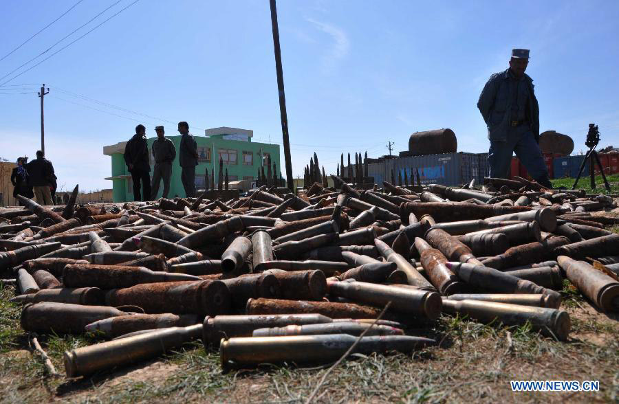 Afghan policemen stand near the weapon cache in Jawzjan Province in northern Afghanistan, March 14, 2013. Afghan security forces found a Taliban weapon cache during an operation in Jawzjan on Thursday, police officials said. (Xinhua/Arui)