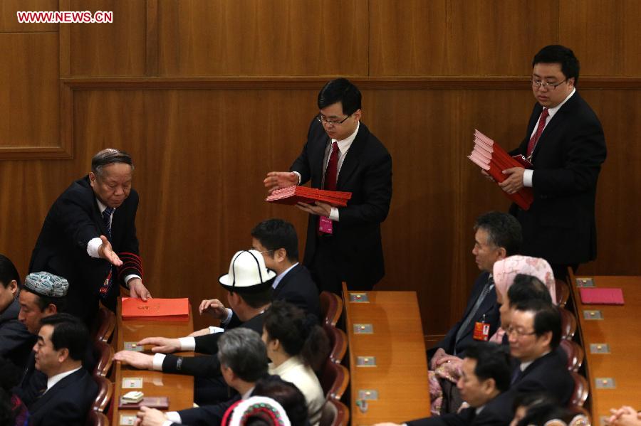 Staff members distribute voting sheets at the fifth plenary meeting of the first session of the 12th National People's Congress (NPC) at the Great Hall of the People in Beijing, capital of China, March 15, 2013. The meeting will vote to decide on the premier, as well as vice chairpersons and members of the Central Military Commission of the People's Republic of China. President of the Supreme People's Court and procurator-general of the Supreme People's Procuratorate will also be elected. (Xinhua/Jin Liwang)