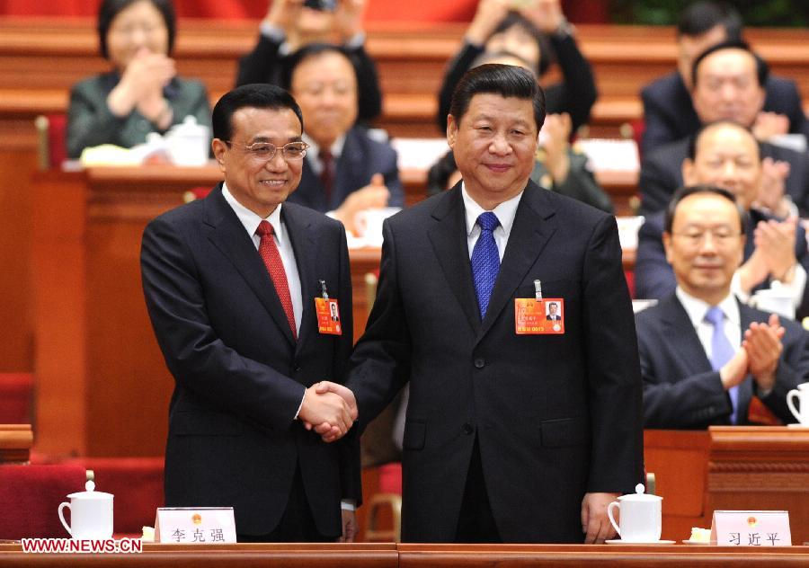 Xi Jinping (R) shakes hands with Li Keqiang at the fifth plenary meeting of the first session of the 12th National People's Congress (NPC) at the Great Hall of the People in Beijing, capital of China, March 15, 2013. Li Keqiang was endorsed as the premier of China's State Council at the meeting here on Friday. (Xinhua/Li Tao)