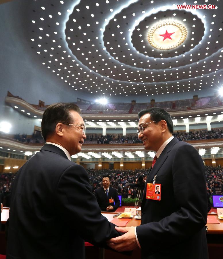 Wen Jiabao (L) shakes hands with Li Keqiang at the fifth plenary meeting of the first session of the 12th National People's Congress (NPC) at the Great Hall of the People in Beijing, capital of China, March 15, 2013. Li Keqiang was endorsed as the premier of China's State Council at the meeting here on Friday. (Xinhua/Lan Hongguang)