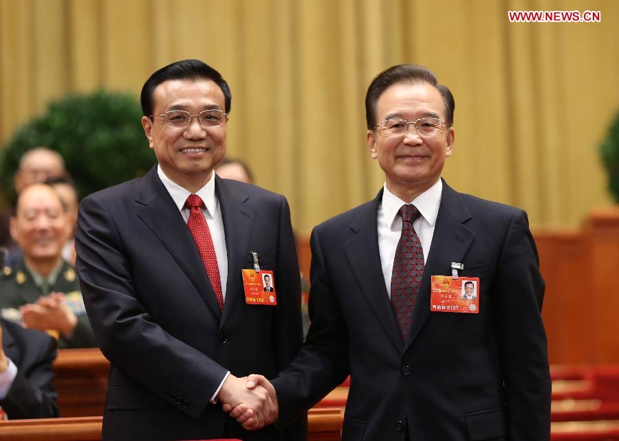 Wen Jiabao (R) shakes hands with Li Keqiang at the fifth plenary meeting of the first session of the 12th National People's Congress (NPC) at the Great Hall of the People in Beijing, capital of China, March 15, 2013. Li Keqiang was endorsed as the premier of China's State Council at the meeting here on Friday. (Xinhua/Lan Hongguang)