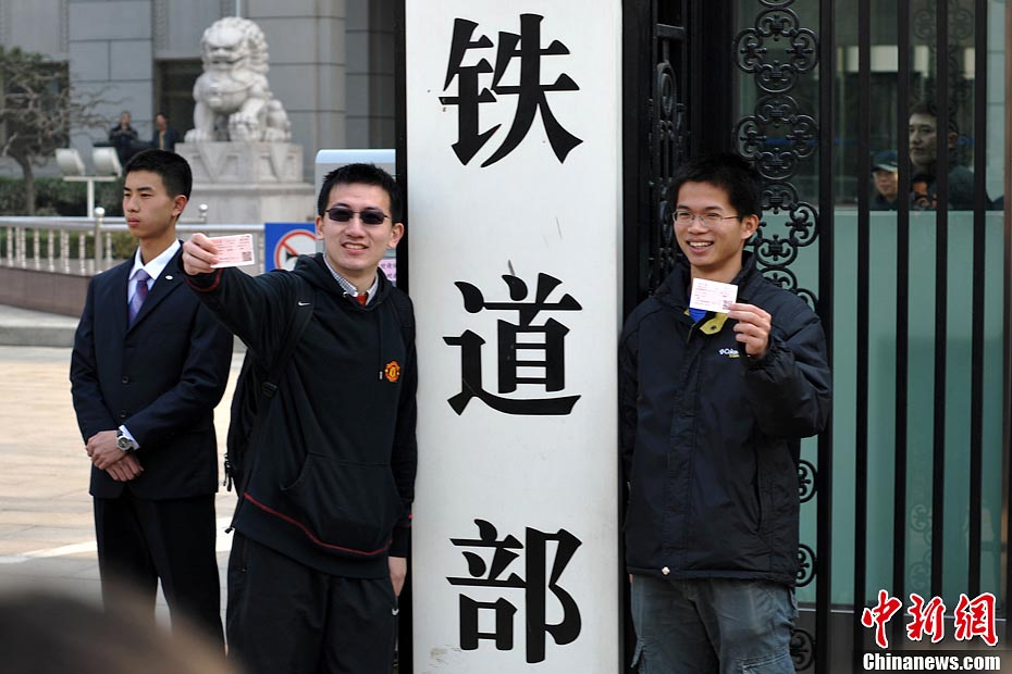 Nostalgic residents line up outside the headquarters of the Ministry of Railway to take photos with its sign yesterday afternoon. On the day, the first session of the 12th NPC endorsed the government restructuring plan, according to which the Ministry of Railway would be dissolved.（Photo/Chinanews.com）