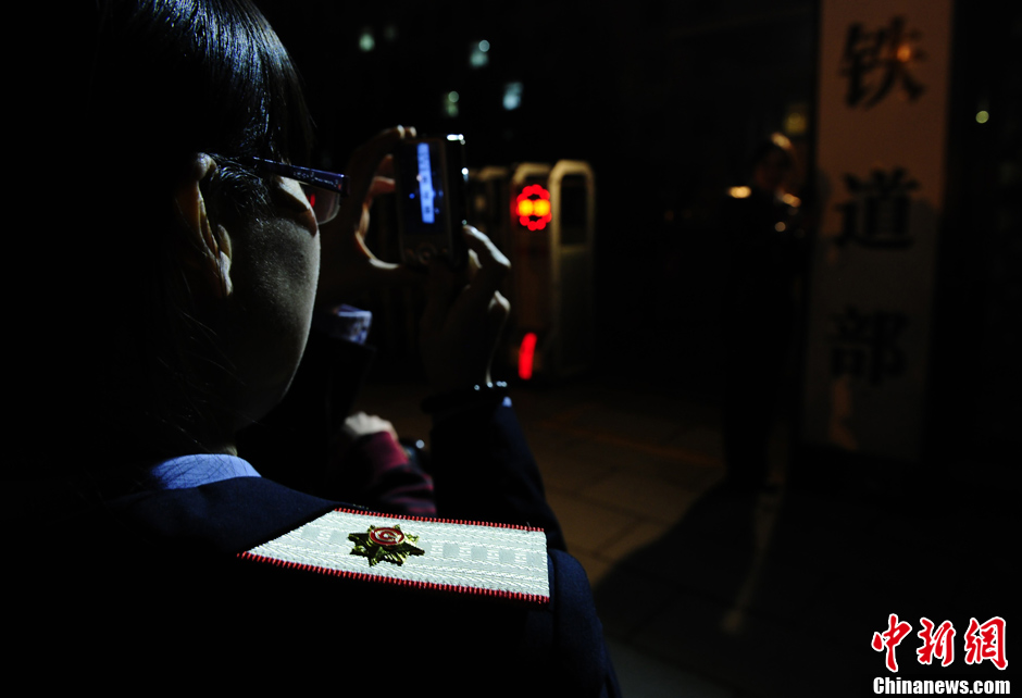 Nostalgic residents line up outside the headquarters of the Ministry of Railway to take photos with its sign yesterday afternoon. On the day, the first session of the 12th NPC endorsed the government restructuring plan, according to which the Ministry of Railway would be dissolved.（Photo/Chinanews.com）