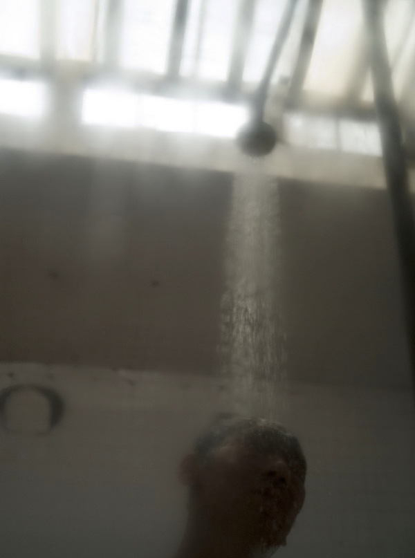 A man takes shower in Shuangxintang in the six-meter high bathhouse. (Xinhua Photo/ Wang Shen)