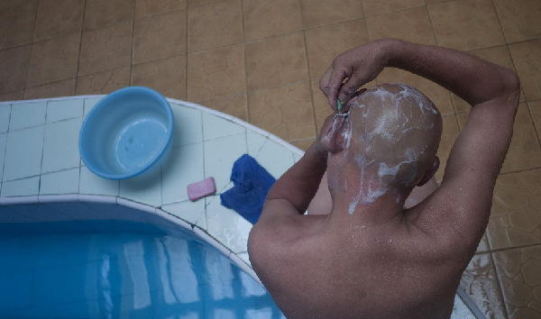 A guest shave his head in Shuangxingtang. (Xinhua Photo/ Wang Shen)