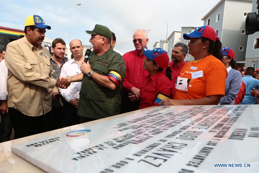 Image provided by Presidency of Venezuela, shows Venezuelan Acting President Nicolas Maduro (L), attending a delivery ceremony of houses built by the government for homeless people, in Playa Grande, in Vargas State, Venezuela, on March 14, 2013. (Xinhua/Presidency of Venezuela)