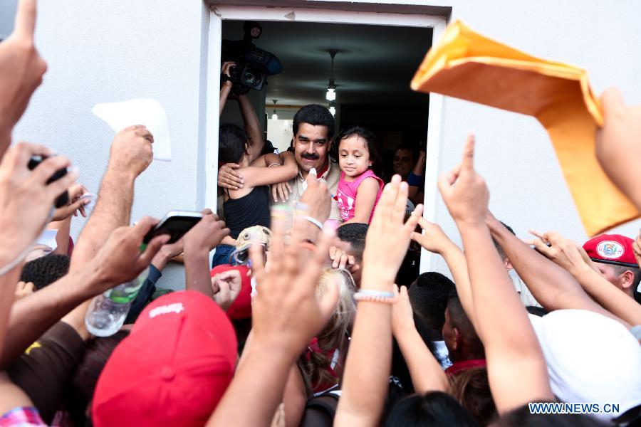 Image provided by Presidency of Venezuela, shows Venezuelan Acting President Nicolas Maduro (C), attending a delivery ceremony of houses built by the government for homeless people, in Playa Grande, in Vargas State, Venezuela, on March 14, 2013. (Xinhua/Presidency of Venezuela)