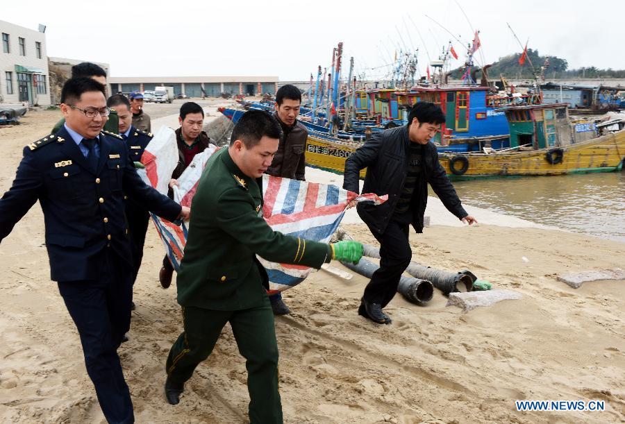 Policemen and fishermen rescue the injured finless porpoise in Changle, southeast China's Fujian Province, March 15, 2013. Two injured finless porpoises were rescued and freed to sea by local people on Friday. (Xinhua/Zhang Guojun)