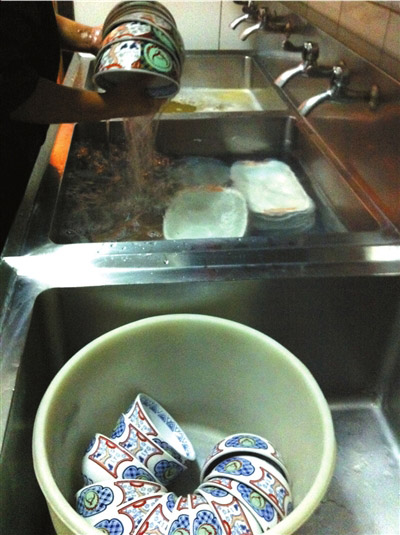 Dinning bowls are roughly washed with short disinfection time in Yoshinoya’s restaurant located in Dongzhimen, Chaoyang district during dining peak time. (Beijing Times)