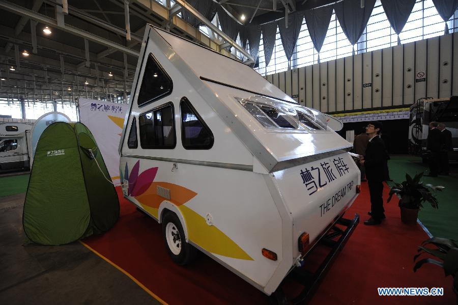 A visitor watches a budget motor home during the 2013 China International Exhibition for Caravanning, Motoring, Tourism (CMT China) in Nanjing, capital of east China's Jiangsu Province, March 15, 2013. The three-day exhibition, with the participation of 289 exhibitors from 28 countries and regions, opened in Nanjing Friday. (Xinhua/Shen Peng) 