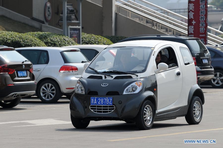 A man drives a rented electric car in Hangzhou, capital of east China's Zhejiang Province, March 15, 2013. Hangzhou launched a rental service of electric vehicles recently, offering a three-month term with a fee of 998 Yuan per-month. (Xinhua/Ju Huanzong)