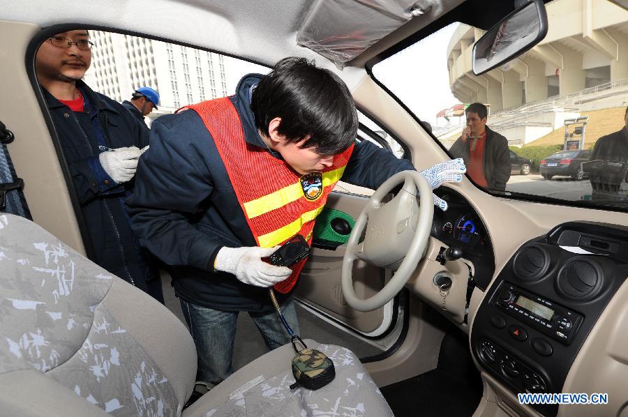 A worker checks the meters of an electric car at a power station in Hangzhou, capital of east China's Zhejiang Province, March 15, 2013. Hangzhou launched a rental service of electric vehicles recently, offering a three-month term with a fee of 998 Yuan per-month. (Xinhua/Ju Huanzong)