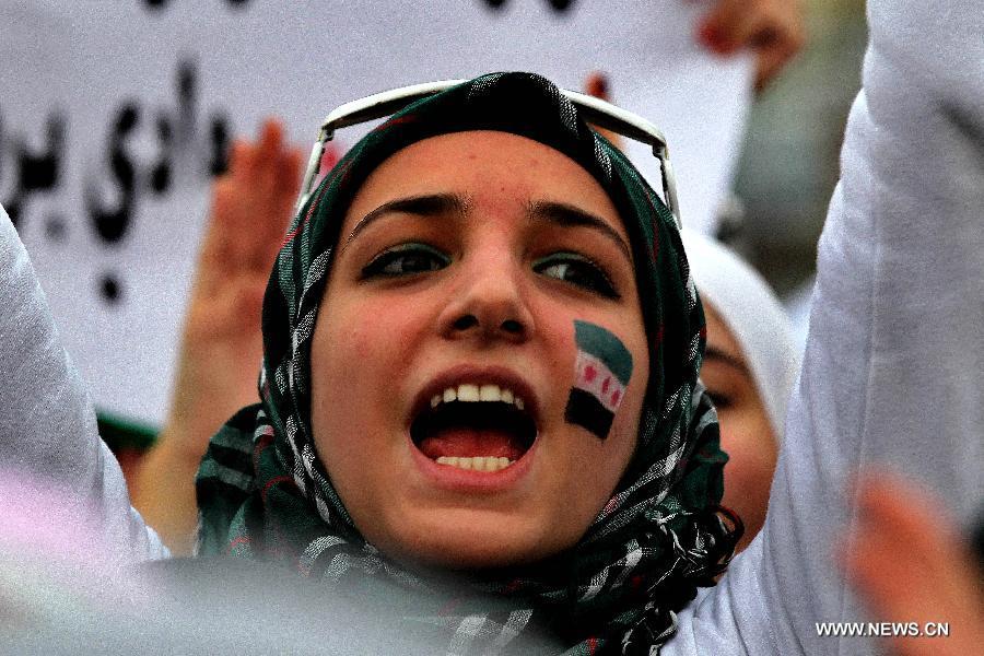 A Syrian woman living in Jordan holds Syrian revolutionary flags and shouts slogans against President Bashar al-Assad during a rally in front of the Syrian embassy in Amman, Jordan, March 15, 2013. Hundreds gathered in front of the Syrian embassy to mark the second anniversary of the start of the conflict against the regime of Al-Assad. (Xinhua/Mohammad Abu Ghosh) 