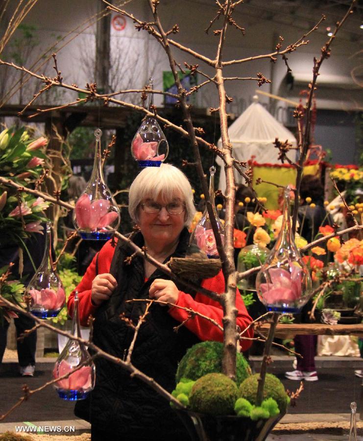 A woman views flowers in bottles during the 17th Canada Blooms exhibition at the Canadian National Exhibition center in Toronto, Canada, March 15, 2013. As Canada's largest flower and garden festival, the 10-day event kicked off on Friday and was expected to attract over 200,000 visitors. (Xinhua/Ma Dan)