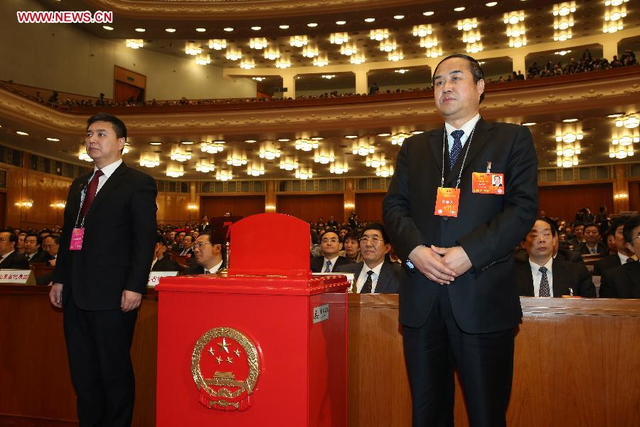 A member of the intendancy (R) stands beside a ballot box during the sixth plenary meeting of the first session of the 12th National People's Congress (NPC) at the Great Hall of the People in Beijing, capital of China, March 16, 2013. (Xinhua/Chen Jianli) 