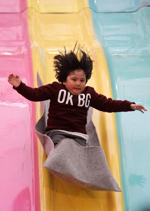 A girl enjoys sliding at the Playdome carnival held at BC Place stadium in Vancouver, Canada. March 16, 2013. (Xinhua/Liang Sen) 