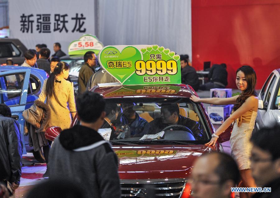 Local residents experience a car costing 9,999 RMB during a four-day automobile show in Urumqi, capital of northwest China's Xinjiang Uygur Autonomous Region, March 16, 2013. More than 1,000 types of vehicles from over 80 automakers were displayed at the show that kicked off on Friday. (Xinhua/Jiang Wenyao) 