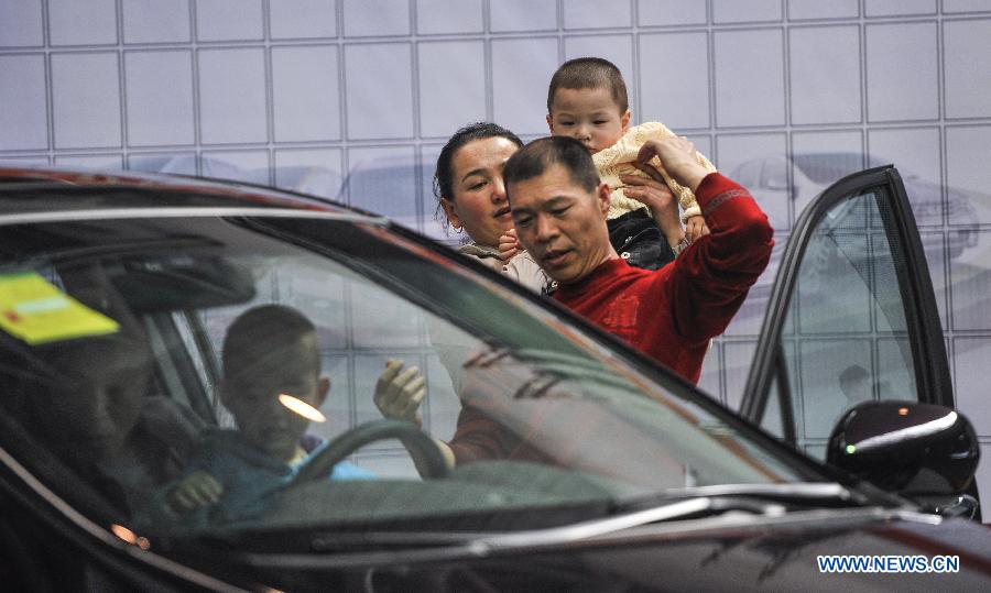 Local residents experience a car during a four-day automobile show in Urumqi, capital of northwest China's Xinjiang Uygur Autonomous Region, March 16, 2013. More than 1,000 types of vehicles from over 80 automakers were displayed at the show that kicked off on Friday. (Xinhua/Jiang Wenyao) 