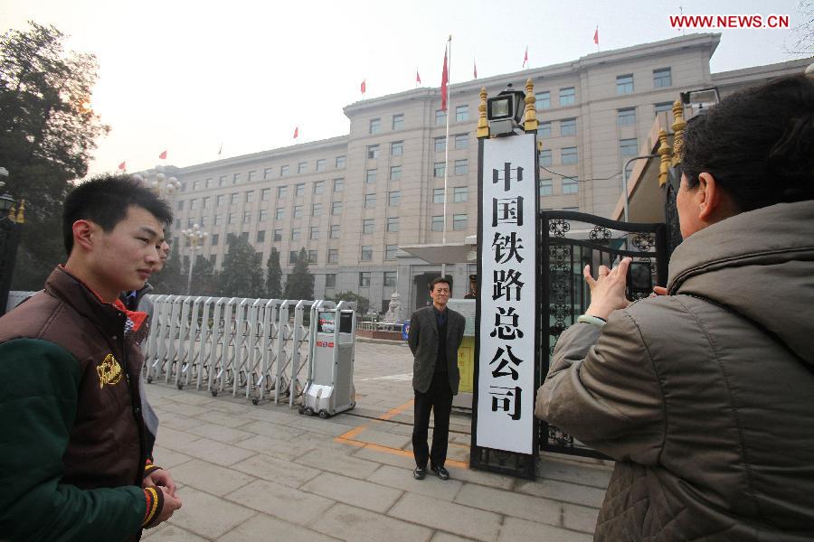 A man poses for a photo at the entrance of the China Railway Corporation, a new state-owned enterprise, in Beijing, capital of China, March 17, 2013. The Chinese government has approved the establishment of the China Railway Corporation to perform the business functions of the defunct Ministry of Railways (MOR) as part of the country's cabinet restructuring plan. (Xinhua)