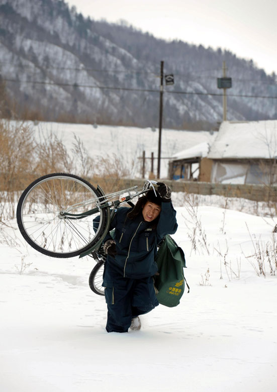 Zhang Zhencao, a postman working in the remote border county Jiaying, northeast China’s Heilongjiang province, struggles to cross the knee-high snow, March  14, 2013. (Xinhua/Wang Song)