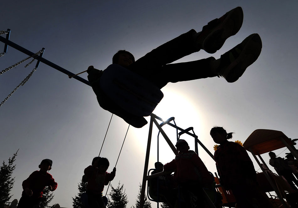 Children play on a swing in an eco-village in Ningxia Hui autonomous region, March 14, 2013. (Xinhua/Peng Zhaozhi)