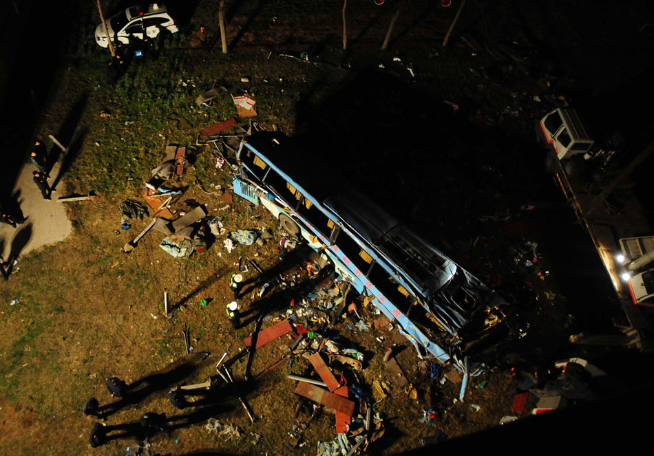 Rescuers search for lives around a crushed sleeper coach, which fell off from a bridge in Jingzhou, southern China’s Hubei province, March 12, 2013. 14  passengers were killed and nine were injured in the accident. (Xinhua/Xiao Yijiu)