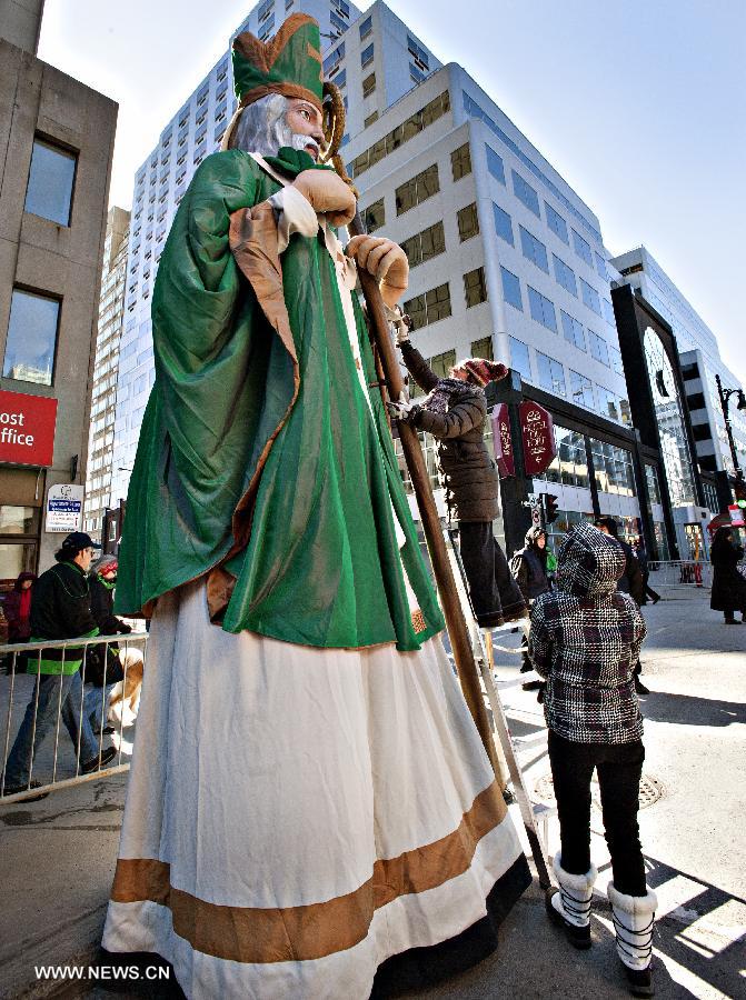 A staff member puts the finishing touches on the giant effigy of Saint Patrick druing the annual St. Patrick's Day celebration in Montreal, Quebec, Canada, March 17, 2013. Despite the bitter cold, an estimated 250,000 Montrealers lined the streets of the city to witness more than 100 organizations that took part in the event with floats and performances for the parade. (Xinhua/Andrew Soong)