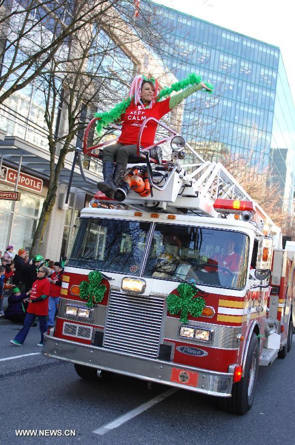 A bus drives during the annual St. Patrick's Day Parade in Vancouver, Canada, March 17, 2013. Thousands of people have crowded downtown Vancouver to watch as bagpipers, Irish dancers and hurlers paraded with dreadlocked dancers, green samba queens, and even a roller derby team took part in the 9th annual St. Patrick's Day parade. The festivities continue the centuries-old custom of partying on the saint's feast day, March 17, to honour his role of helping convert the Irish to the Catholic faith. (Xinhua/Sergei Bachlakov)