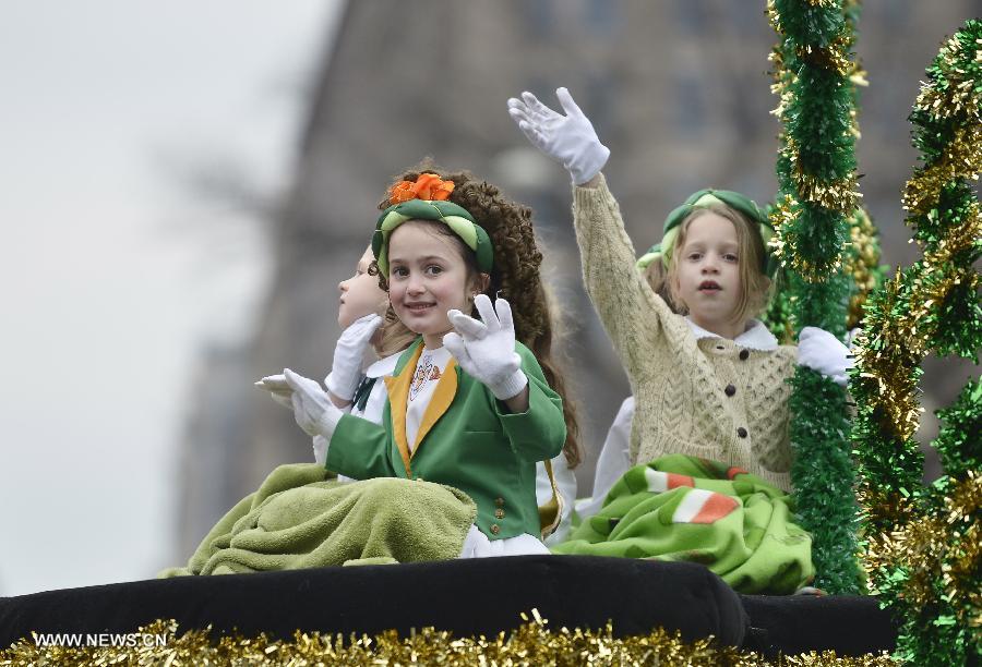 Girls wave to revelers during the annual St. Patrick's Parade in Washington D.C., capital of the United States, March 17, 2013. (Xinhua/Zhang Jun)