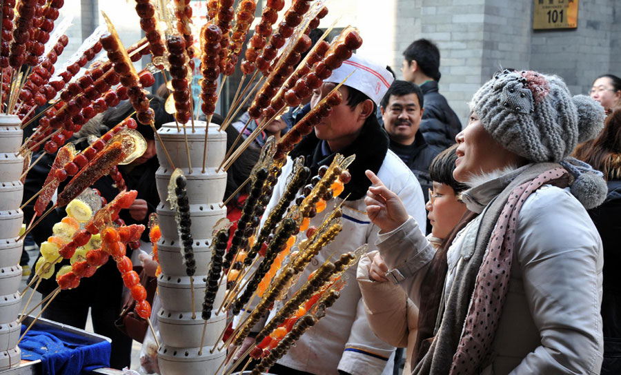 Tourists are queuing to buy traditional Beijing snacks in a snack street of Qianmen. (Photo/Xinhua)