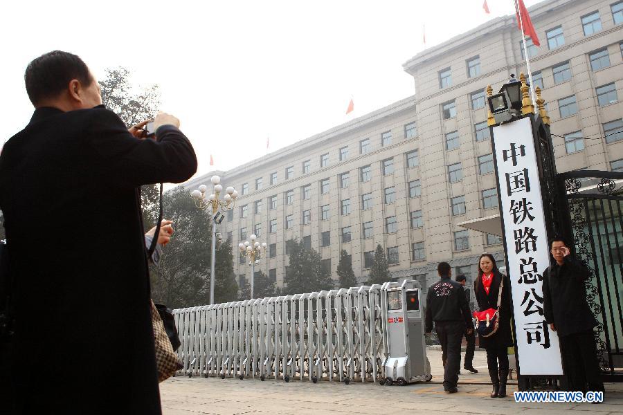 People pose with the name board of China Railway Corporation in Beijing, capital of China, March 17, 2013. The newly-founded China Railway Corporation hung out its name board on Sunday. (Xinhua/Xu Zijian)