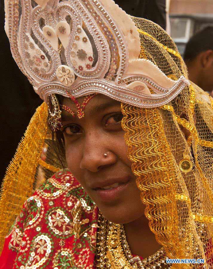 An Indian bride poses for photos during a mass marriage ceremony in Calcutta, capital of eastern Indian state West Bengal, March 17, 2013. A total of 51 couples got married in this occasion on Sunday. Mass marriages in India are organized by social organizations primarily to help the economically backward families who can't afford the high ceremony costs as well as the customary dowry and expensive gifts which are still prevalent in many communities. (Xinhua/Tumpa Mondal)