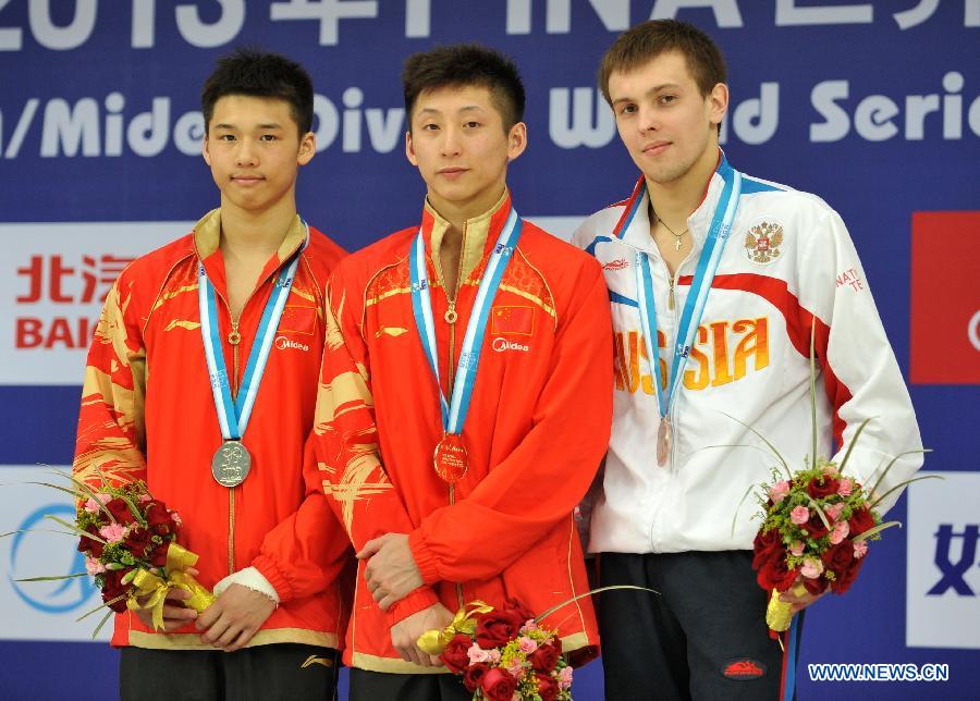 Gold medalist Lin Yue (C) of China and silver medalist Chen Aisen (L) of China are seen on the podium during the awarding ceremony for the Men's 10m platform final at the FINA Diving World Series 2013 held at the Aquatics Center in Beijing, capital of China, on March 17, 2013. Lin Yue claimed the title with 555.55 points. (Xinhua/He Changshan)