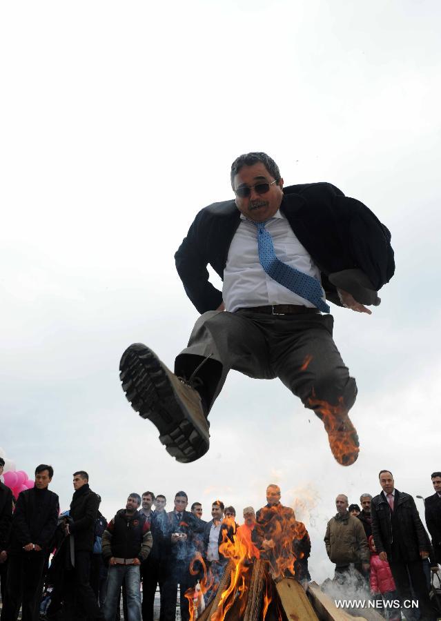 A man jumps over a bunch of fire at Nevruz celebrations in Istanbul, Turkey, on March 17, 2013. The Nevruz performance, organized by the Joint Administration of Turkic Arts and Culture (TURKSOY), brings together more than 250 artists from different countries or regions to celebrate Nevruz in 15 cities of Turkey. (Xinhua/Ma Yan)