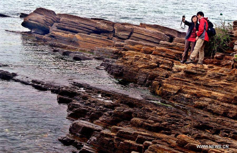 A couple take photos of themselves on the Tung Ping Chau island of south China's Hong Kong, March 17, 2013. Tung Ping Chau lies in the northeast corner of Hong Kong and is part of the Hong Kong Geopark. The island is home to shale rocks in various shapes which makes it a popular tourist attraction. (Xinhua/Chen Xiaowei)
