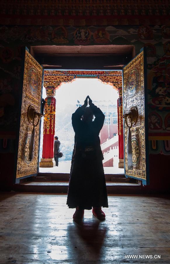 A Tibetan Buddhism worshiper prays at the Guanyin Temple in Jinchuan County, Aba Tibetan Autonomous Region, southwest China's Sichuan Province, March 17, 2013. The temple was first build in the seventh century and hosts the shrine to the Four-Armed Avalokitesvara boddhisattva. (Xinhua/Jiang Hongjing)