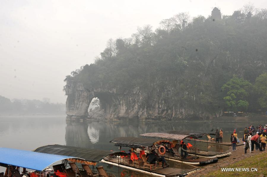 Tourists visit the Xiangbi Mountain in Guilin, southwest China's Guangxi Zhuang Autonomous Region, March 17, 2013. Guilin, a famous tourist resort, boasts of numerous cultural relics and various Karst land features. (Xinhua/Lu Bo'an)