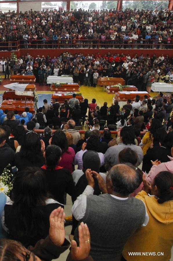 Relatives and friends attend a mass funeral for victims of a fireworks accident at the village of Nativitas in Tlaxcala state, Mexico, on March 17, 2013. At least 13 people were killed and 154 others injured when a truck containing fireworks exploded during a Catholic procession in honor of a local patron saint. (Xinhua/Juan Mateo) 