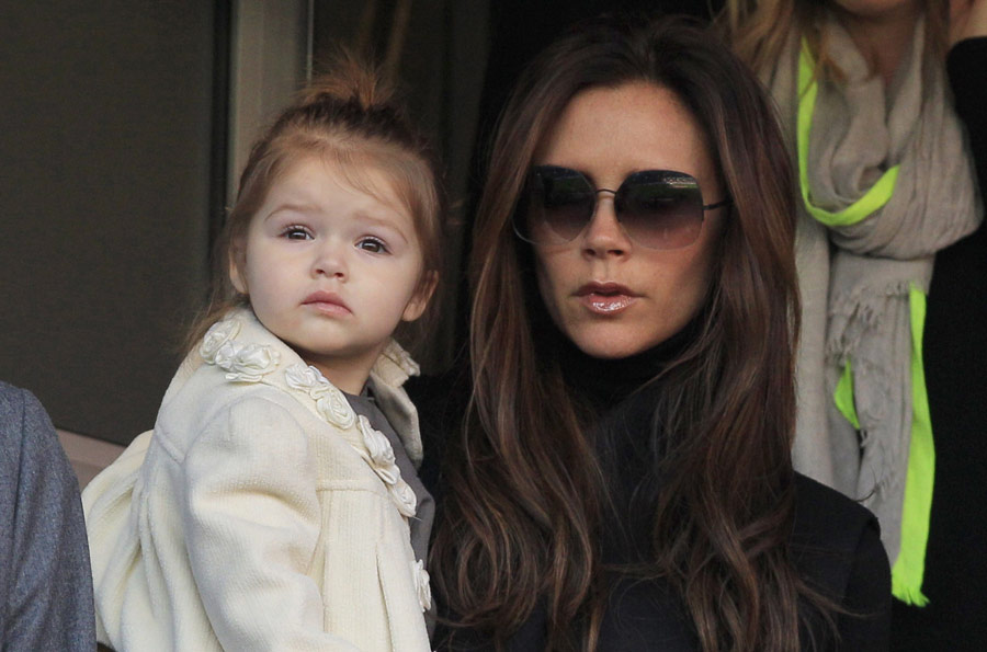 Former Spice Girls singer Victoria Beckham holds her daughter Harper as she arrives for the football match that her husband David Beckham will fight with his Paris Saint-Germain team against Nancy, at the Parc des Princes Stadium in Paris March 9, 2013.(Xinhua News Agency/Reuters)