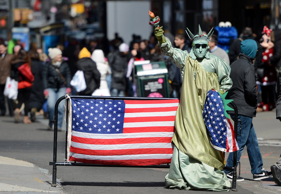 A street performer dressed as the Statue of Liberty strides at the Times Square in New York, U.S., March 14, 2013.Data released on the 14th from U.S. Labor Department shows, last week, the U.S. initial claims for unemployment benefits has fallen to 332,000, lower than economists’ expected 350,000. The moving average of Initial claims for jobless benefits within four weeks decreased 2,750 to 346,750, the lowest point since March 8, 2008, which indicates the U.S. employment market is steadily improving. (/Xinhua/Wang Lei)