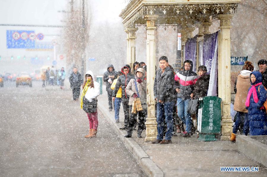 Citizens wait for buses at a bus station amid snowfall in Harbin, capital of northeast China's Heilongjiang Province, March 18, 2013. A cold front brings snow and low temperature to Harbin on March 18. (Xinhua/Wang Song) 