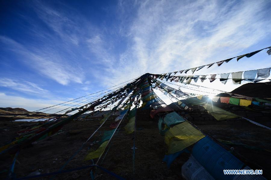 Photo taken on March 17, 2013 shows prayer flags in dawn in the Tanggula Mountains near the border between Qinghai Province and Tibet Autonomous Region in west China.(Xinhua/Wu Gang)