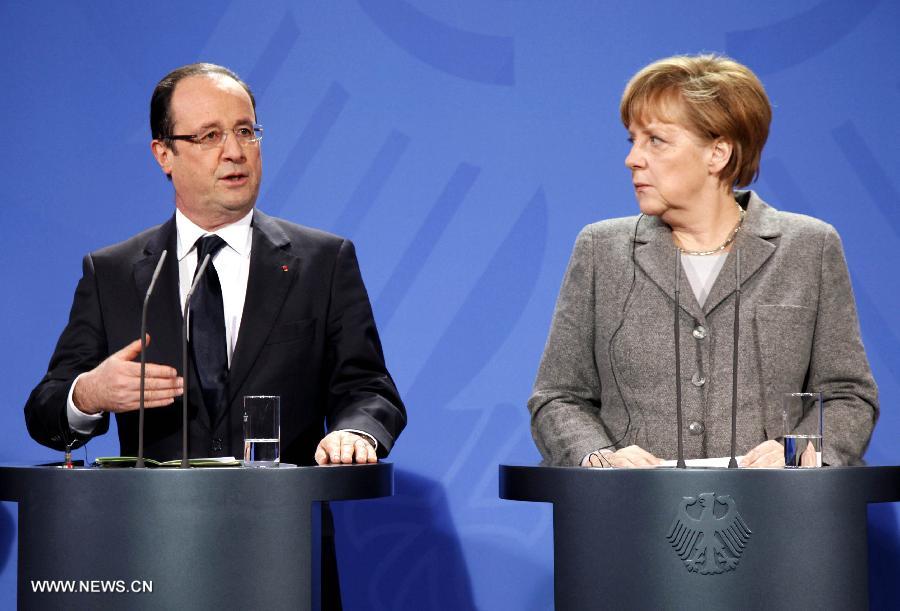 French President Francois Hollande (L) speaks as German Chancellor Angela Merkel looks on during a joint press conference prior to the European Round Table of Industrialists, at the Chancellery in Berlin, Germany, March 18, 2013. The leaders of Germany, France and the European Union Commission pledged to boost growth and competitiveness of the European economy at a meeting on Monday in the German capital. (Xinhua/Pan Xu)