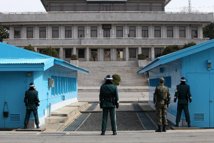 A soldier (rear) of the Democratic People's Republic of Korea (DPRK) stands guard at the truce village of Panmunjom in the demilitarized zone (DMZ) in Paju, South Korea, March 19, 2013. The annual joint military exercises of South Korea and the United States is scheduled to run from March 11 to March 21. (Xinhua/Park Jin-hee) 