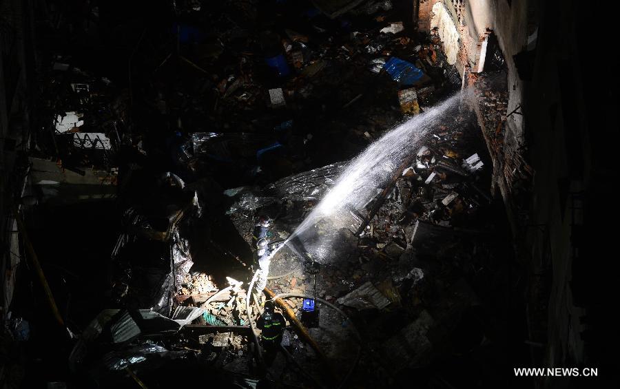 Fire fighters work at the blast locale of a residential building in Wuhan, capital of central China's Hubei Province, March 19, 2013. An explosion ripped through a residential building in Wuhan Tuesday night. Casualties from the blast that broke out at around 10 p.m. in Hanlai Square in the city's Hankou District are still unknown. (Xinhua/Cheng Min)