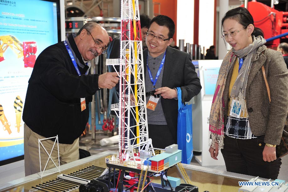 Visitors view a model of a drilling platform at the 13th China International Petroleum & Petrochemical Technology and Equipment Exhibition (CIPPE) in Beijing, capital of China, March 19, 2013. Opened Tuesday at the New China International Exhibition Center, the three-day event attracted some 1,500 exhibitors from 62 countries and regions around the world. (Xinhua/Yang Guang)